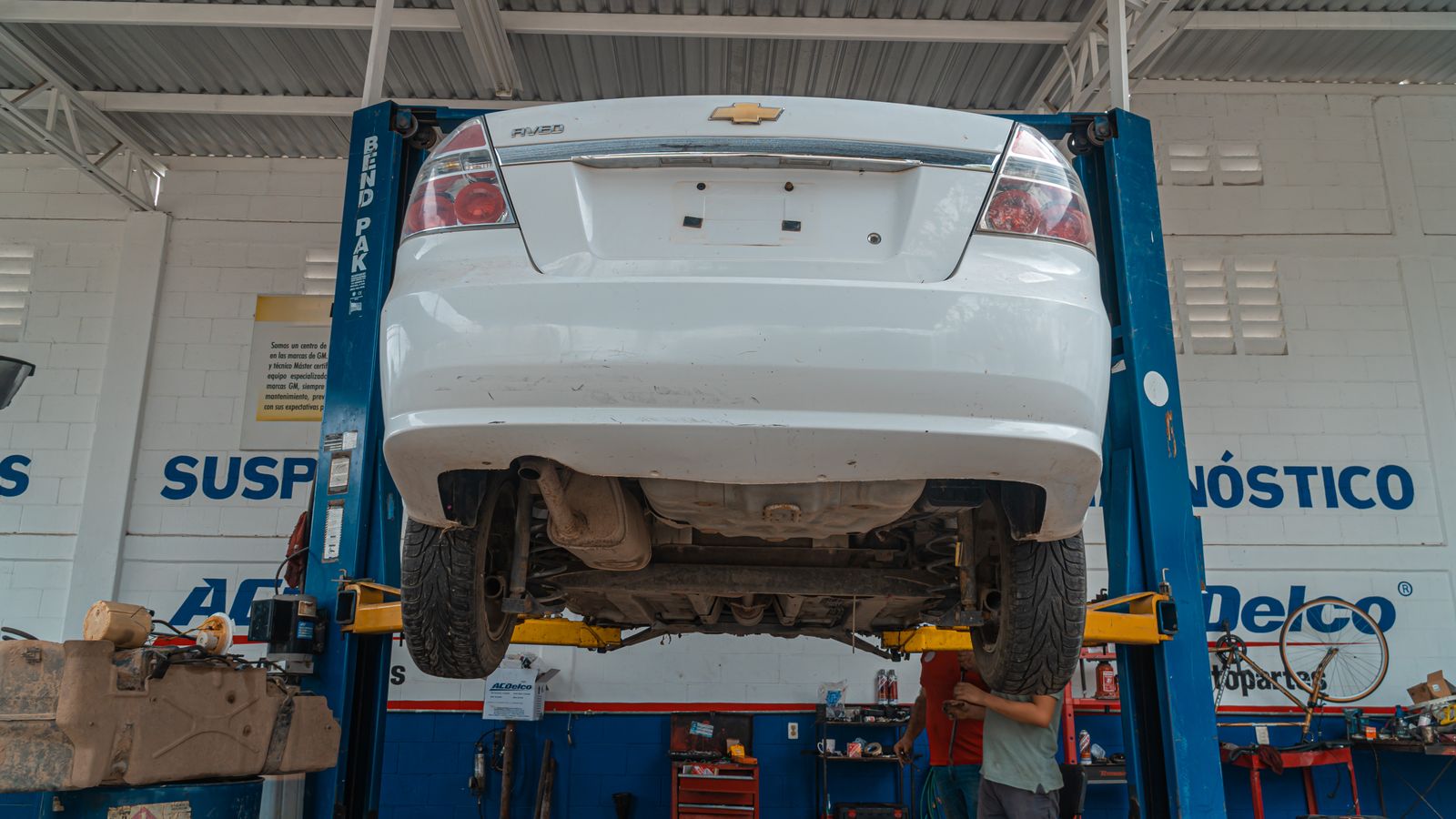 White car raised for maintenance in a repair garage