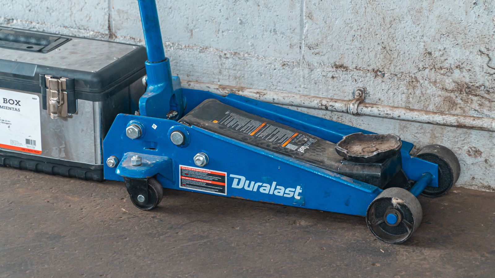 Hydraulic jack and toolbox ready beside a vehicle