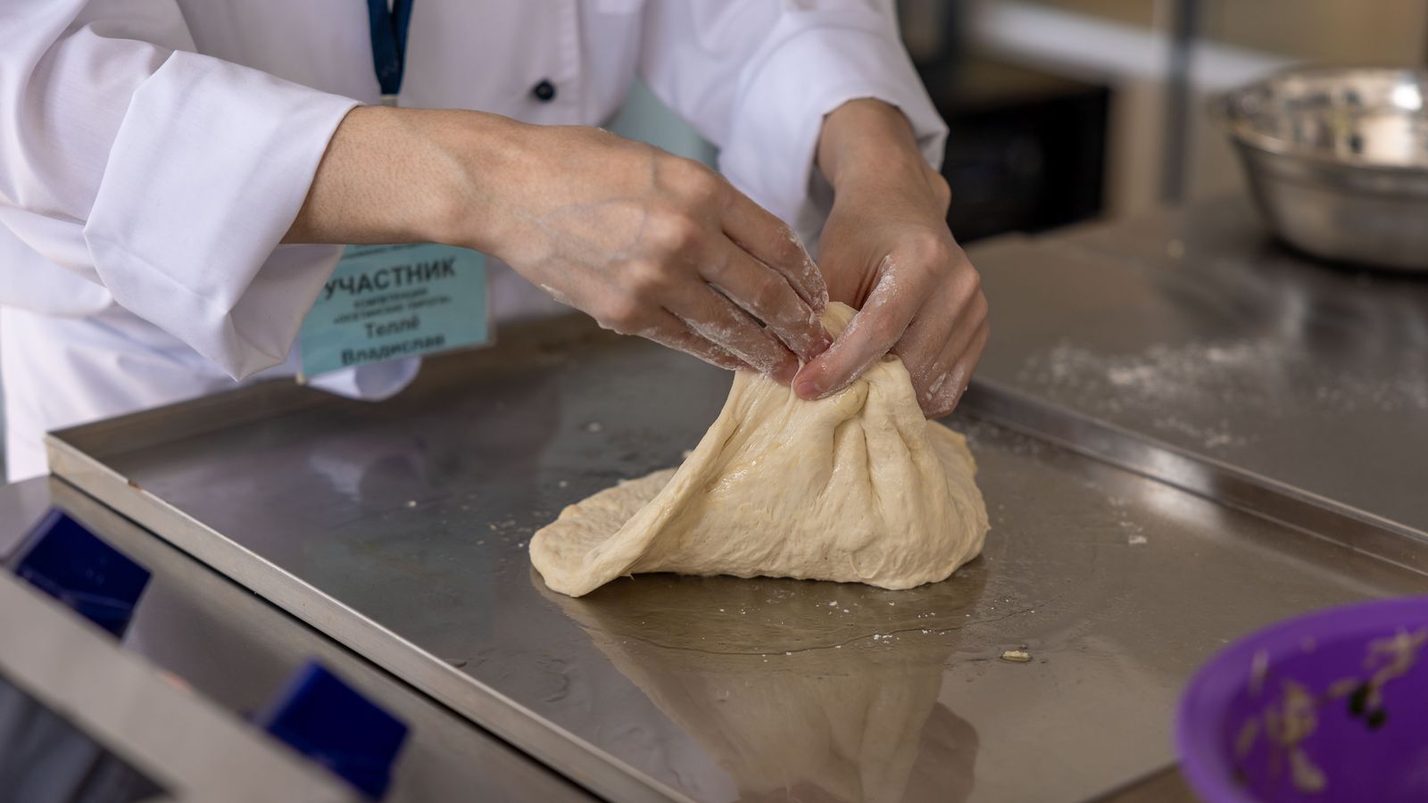 Chef kneading dough in a professional kitchen