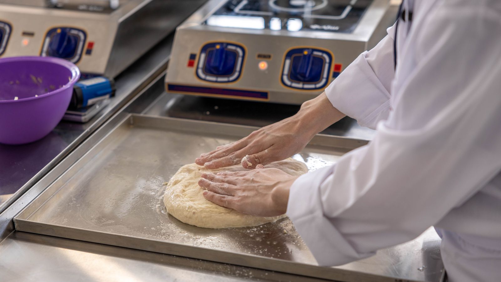 Chef preparing ingredients on a stainless kitchen counter