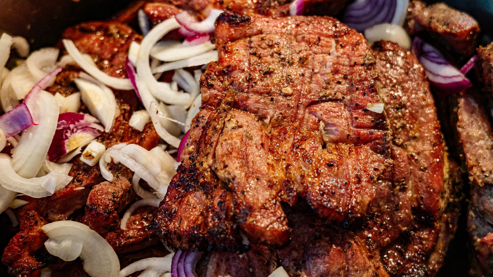 Finished grilled steak resting with a deeply browned surface