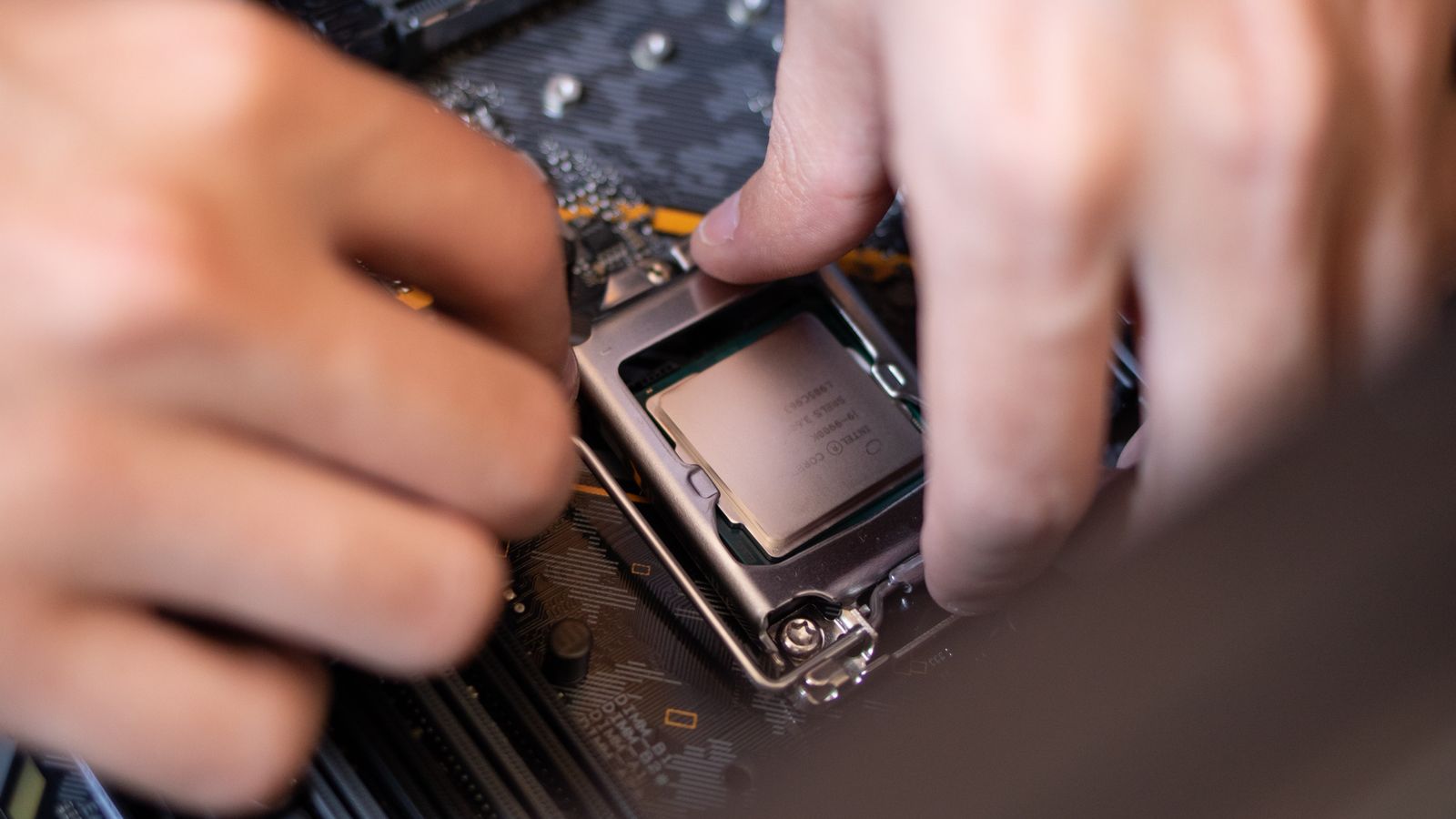 Hands seating a component evenly onto a motherboard
