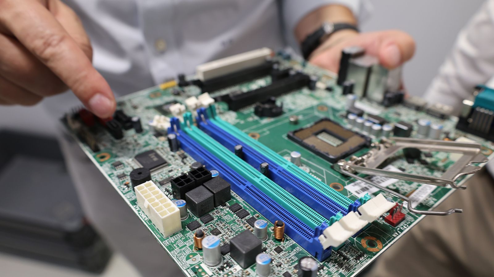 Technician visually verifying a motherboard repair